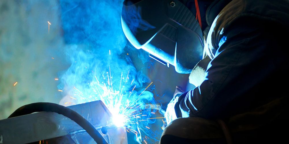Welder creating bright blue sparks Website Header 